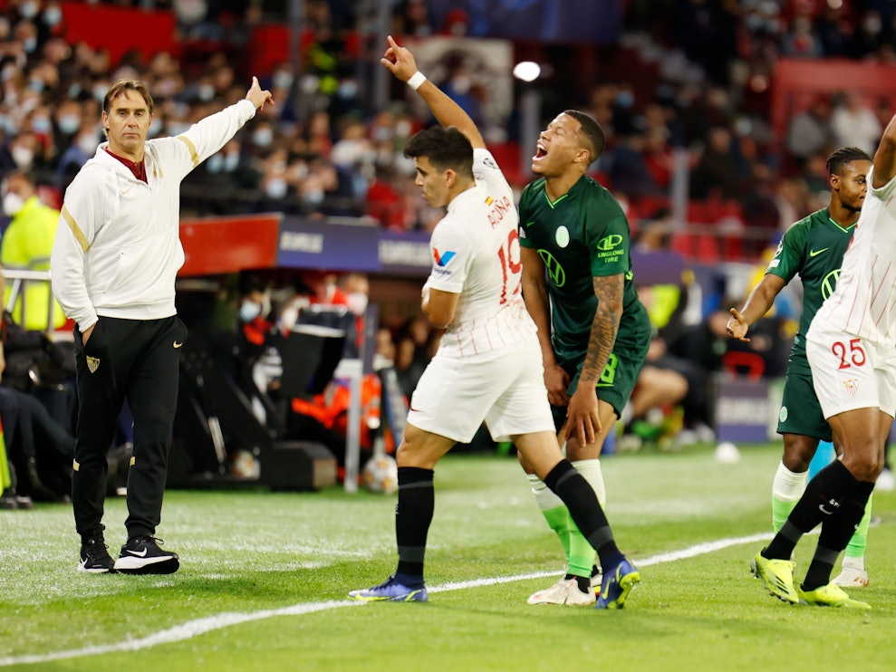 Sevillas Trainer Julen Lopetegui (l) gestikuliert an der Seitenlinie, Wolfsburgs Lukas Nmecha hält sich das Knie.