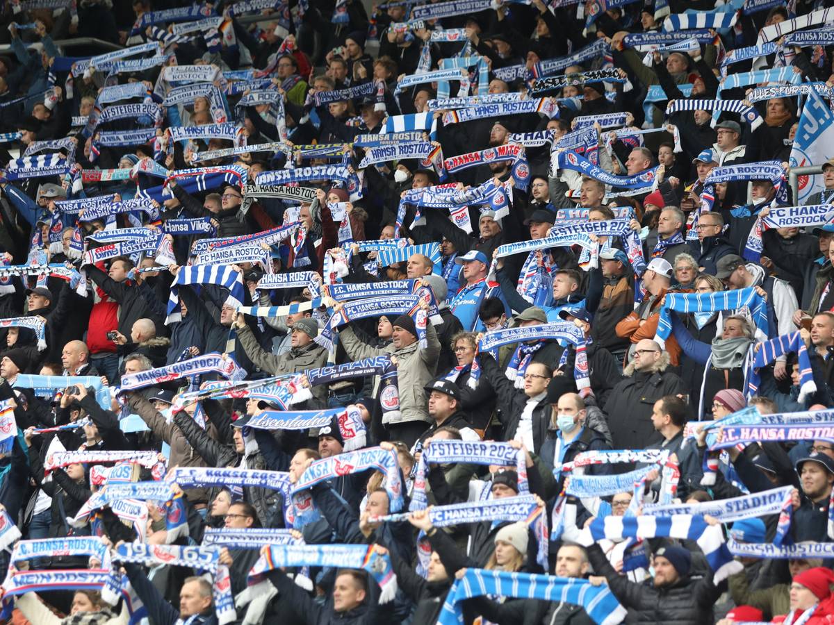 Fans von Hansa Rostock halten ihre Schals im Ostseestadion hoch.
