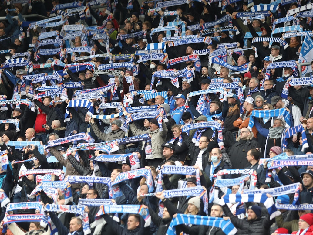 Fans von Hansa Rostock halten ihre Schals im Ostseestadion hoch.