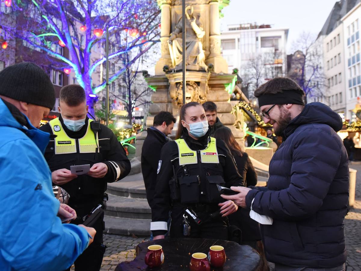 Ordnungsamtsmitarbeiter kontrolliert die 2 G-Nachweise der Besucher auf dem Weihnachtsmarkt am Alter Markt.