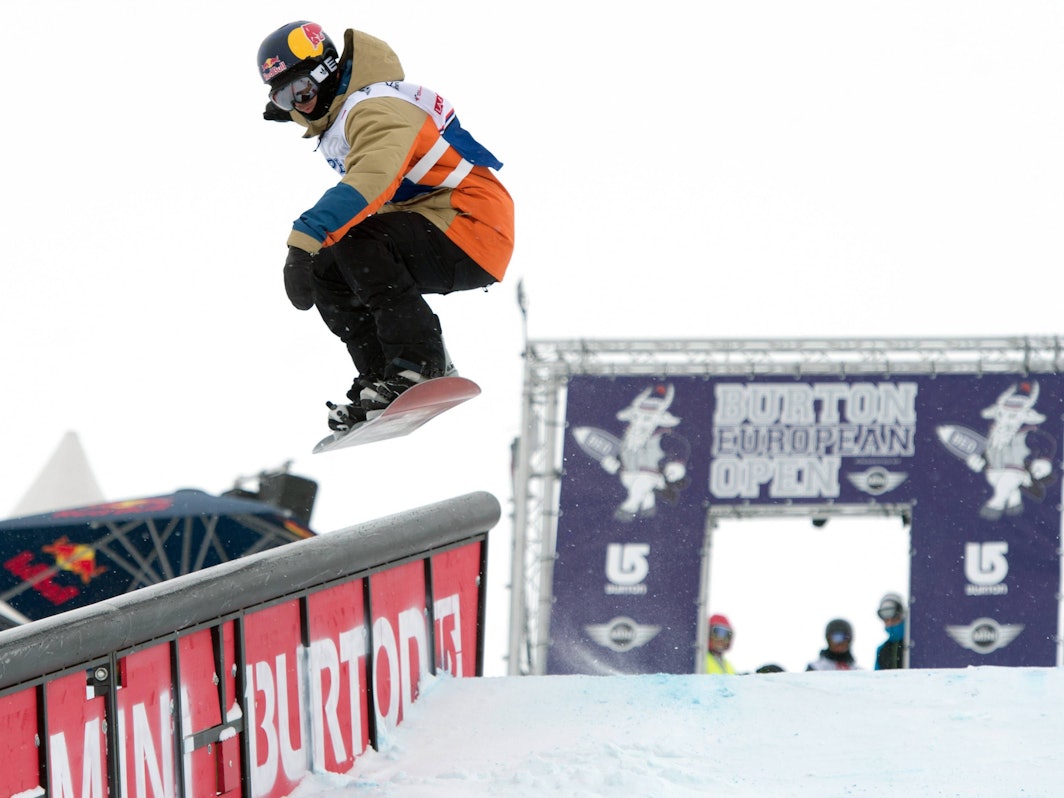 Marko Grilc springt mit seinem Snowboard über eine Schanze.