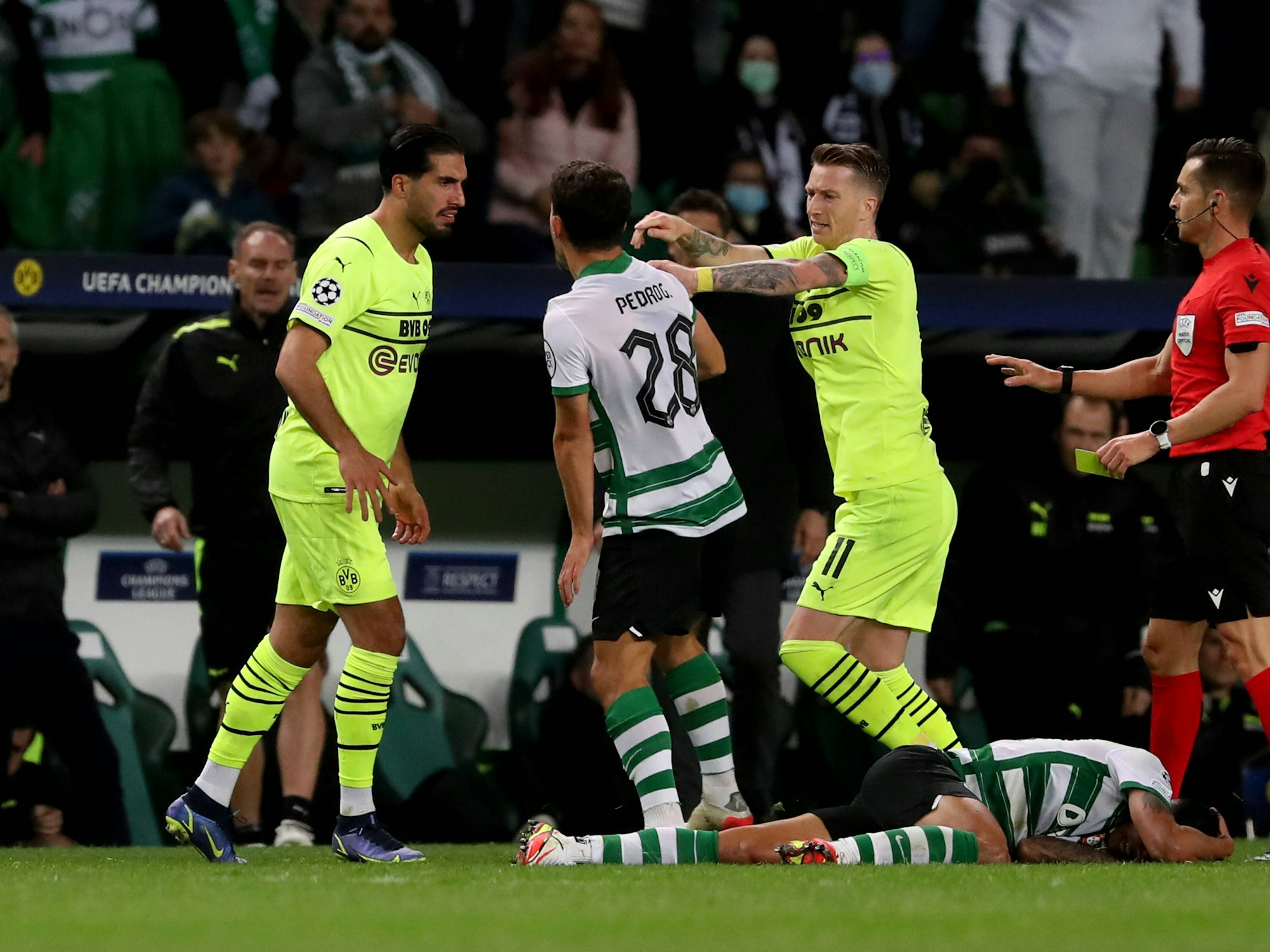 Emre Can und Marco Reus diskutieren mit Pedro Goncalves. Pedro Porro liegt auf dem Platz.