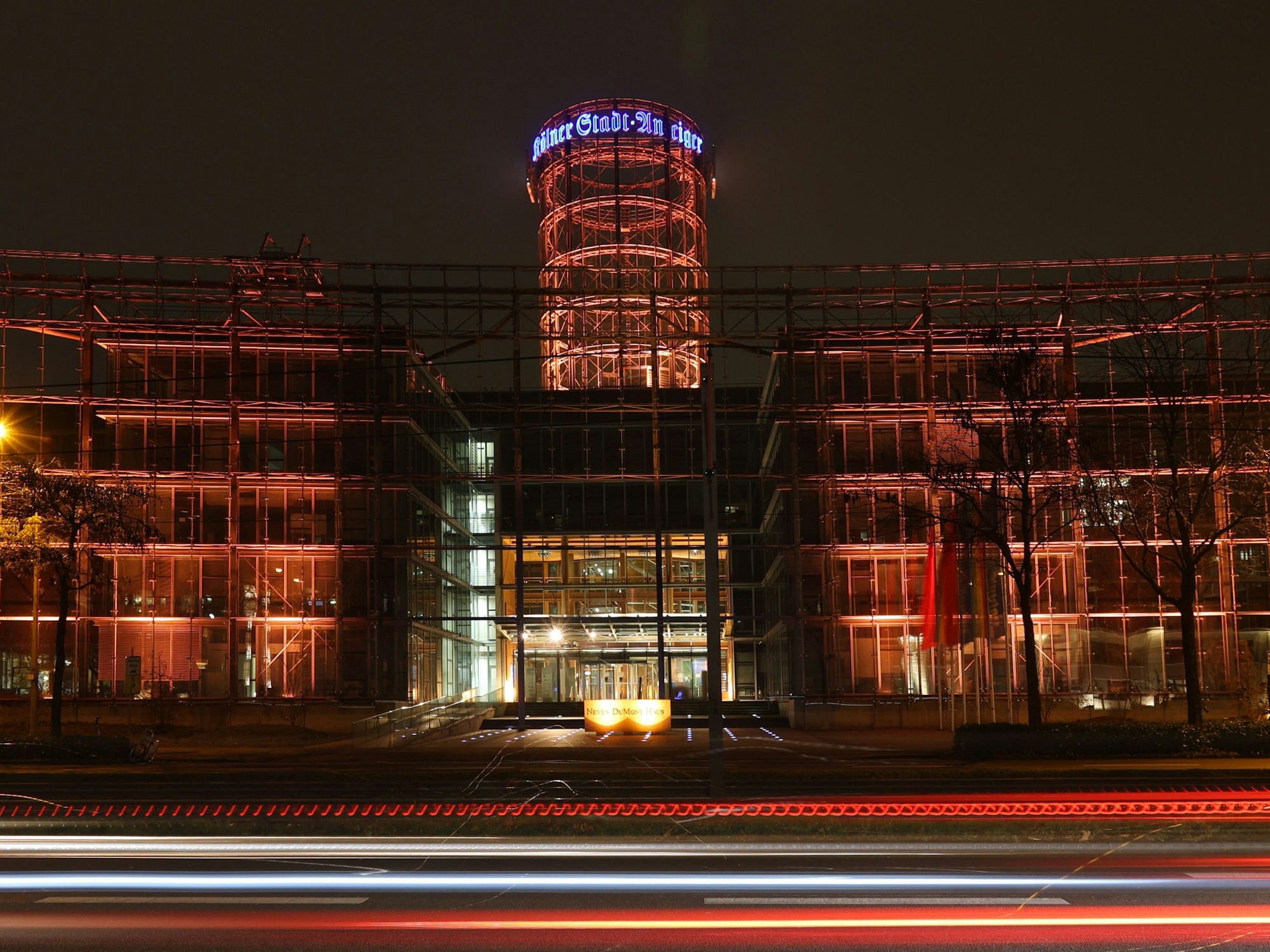 Das Neven DuMont Haus an der Amsterdamer Straße in Köln ist am Donnerstagabend orange angestrahlt. Hintergrund: der internationale Tag gegen Gewalt an Frauen.