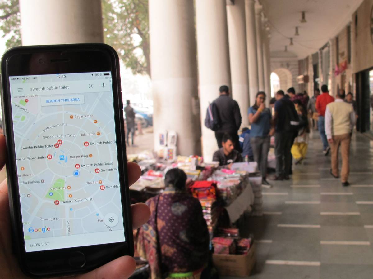 Das Symbolfoto (aufgenommen am 23. Dezember 2016 in Neu Delhi) zeigt ein Handy mit geöffnetem Google Maps, im Hintergrund sieht man den Connaught Place.