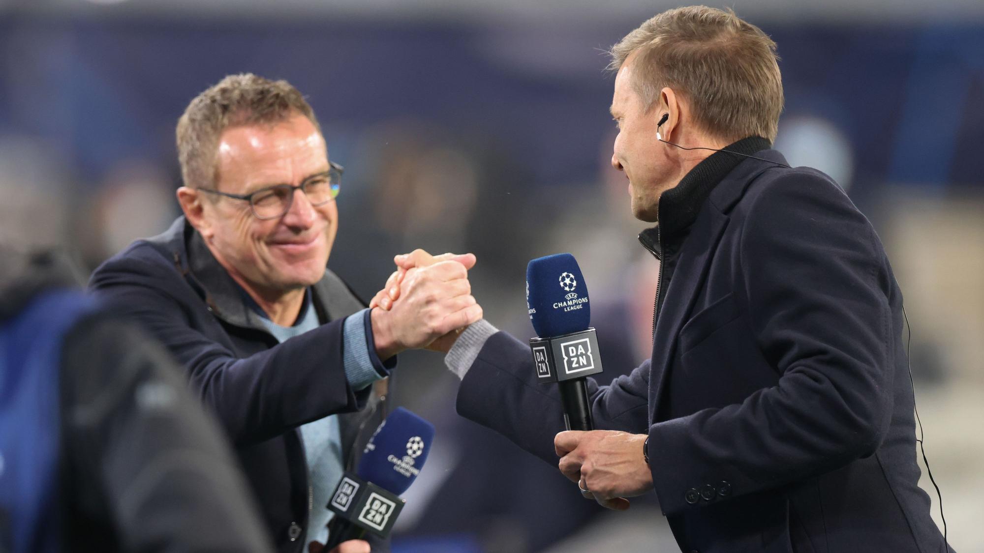 Leipzigs Trainer Jesse Marsch (r) und Leipzigs ehemaliger Trainer Ralf Rangnick schütteln nach einem Interview die Hand.