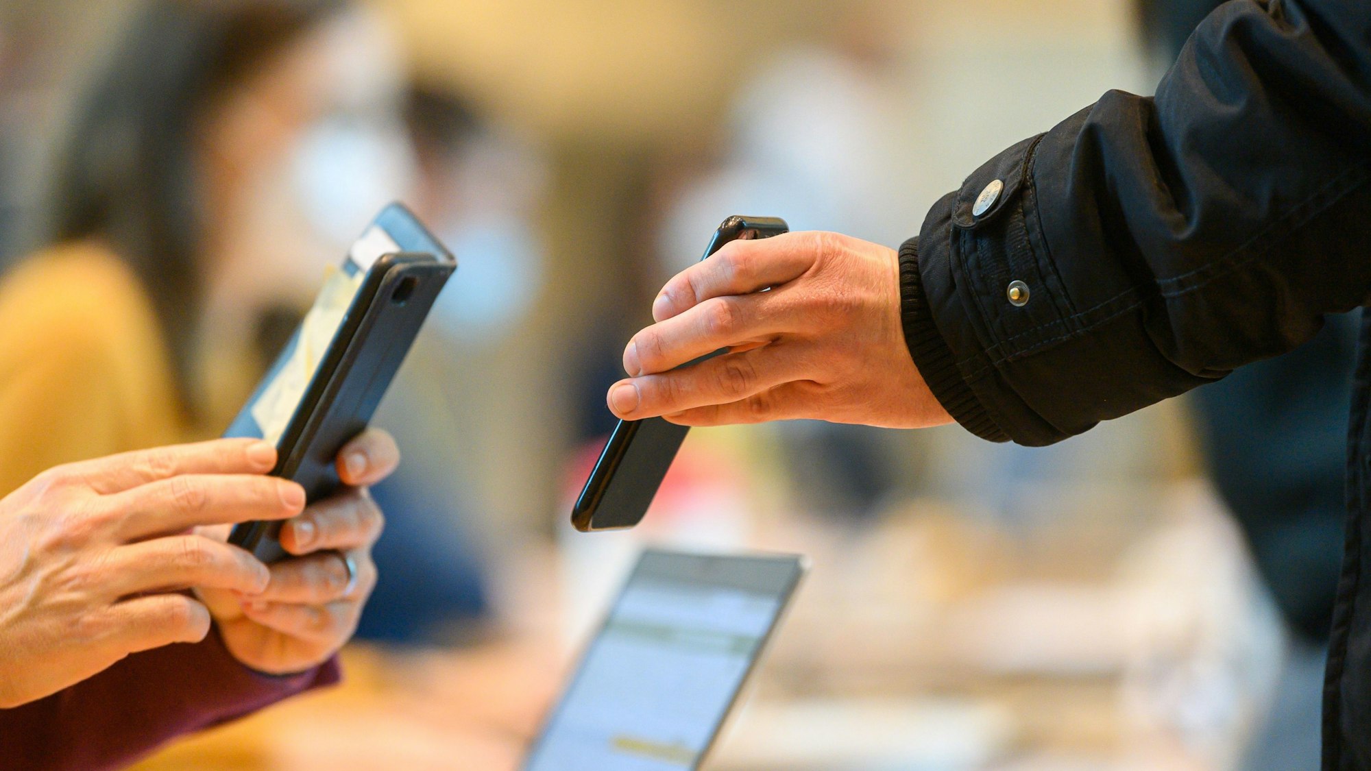 Ein Mitarbeiter des Chipherstellers Globalfoundries (GF) zeigt vor Dienstbeginn in der Lobby des Werks sein Impfzertifikat.