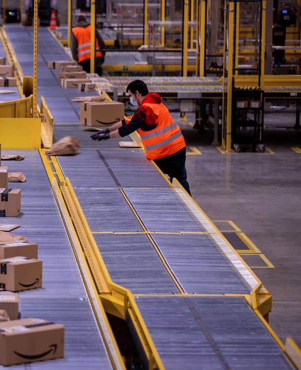 Ein Mitarbeiter sortiert an einem Transportband Paketsendungen im neuen Verteilzentrum des Online-Händlers Amazon.