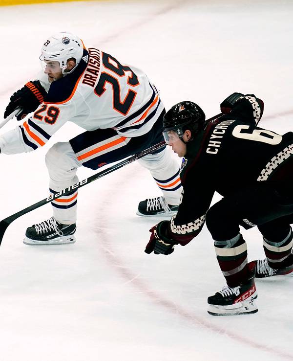 Eishockey-Profi Leon Draisaitl (l.) befindet sich im Sprintduell mit Jakob Chychrun, beide jagen dem Puck nach.