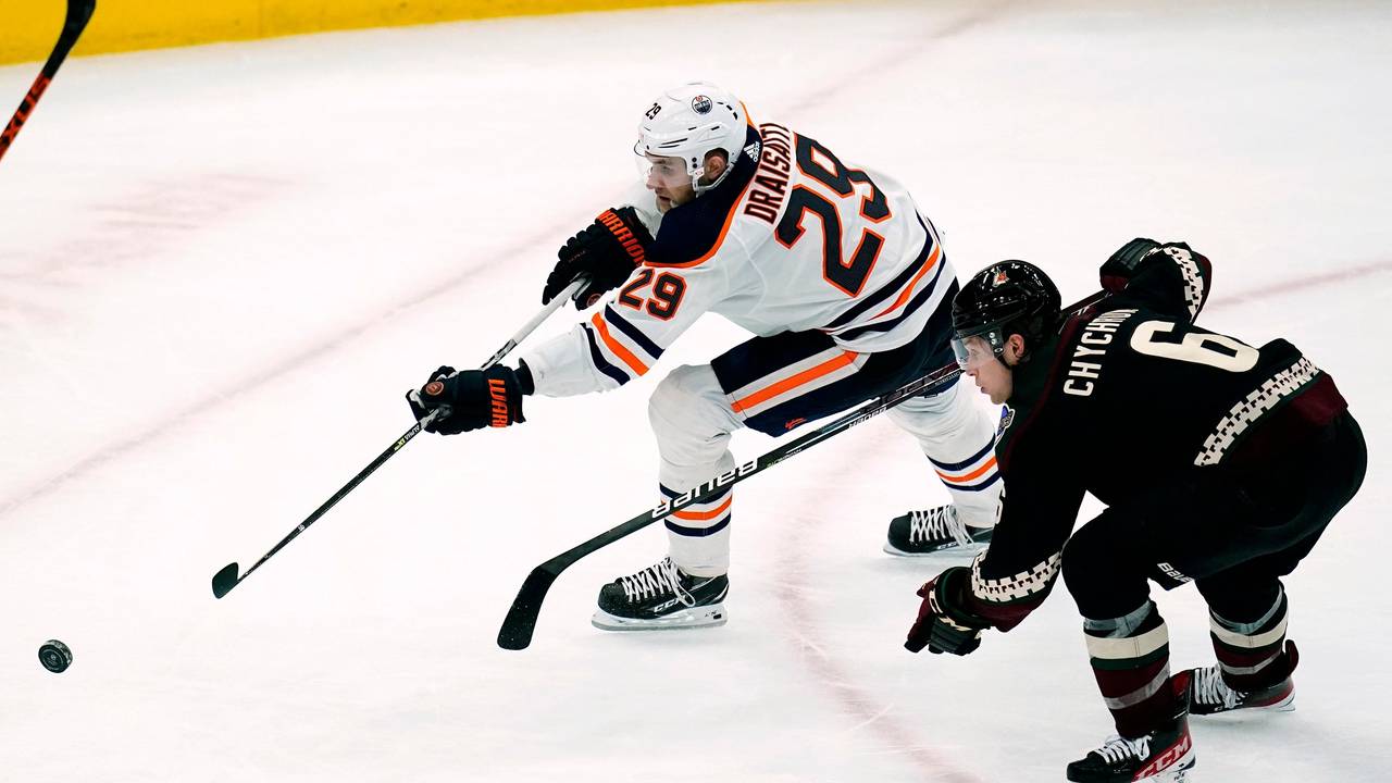 Eishockey-Profi Leon Draisaitl (l.) befindet sich im Sprintduell mit Jakob Chychrun, beide jagen dem Puck nach.