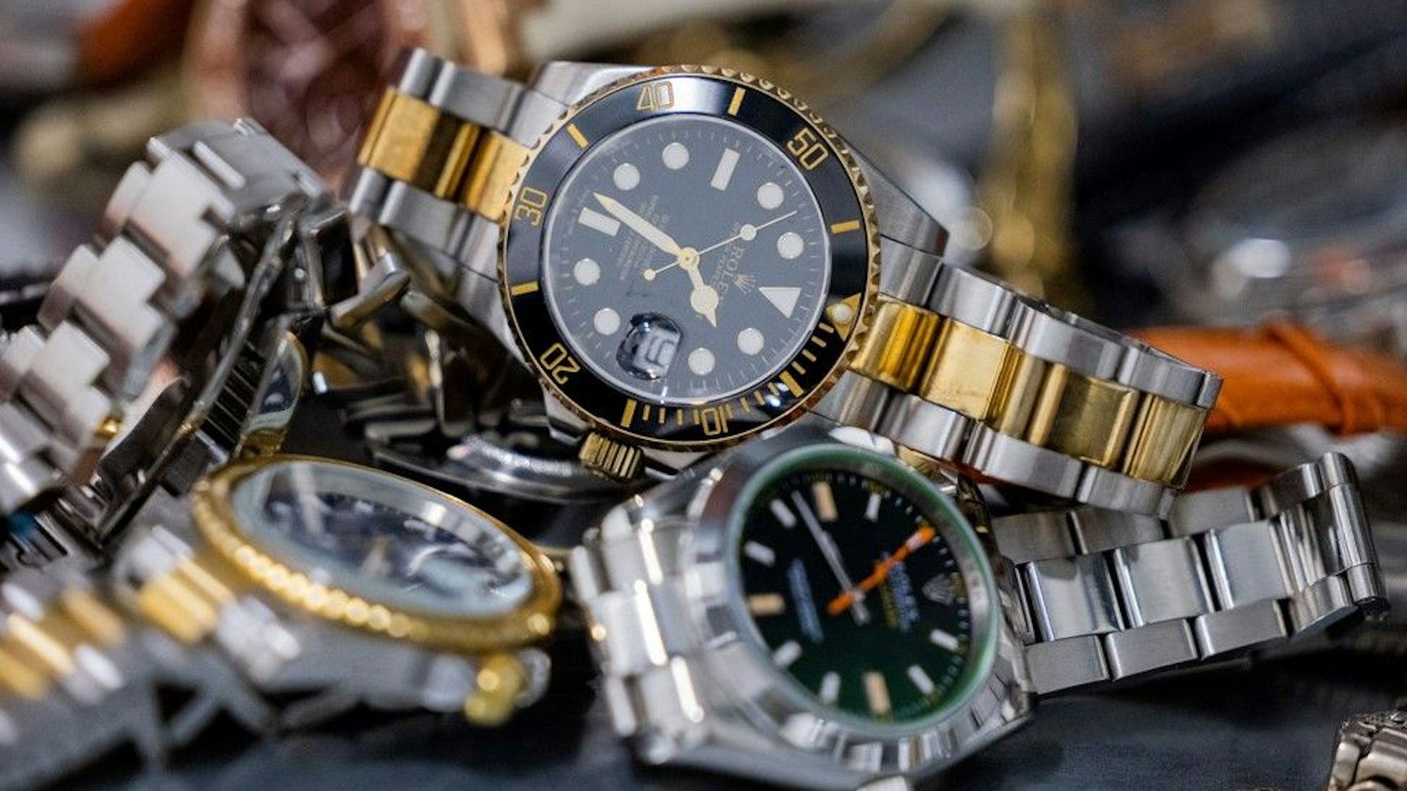 Gefälschte Markenuhren liegen im Hauptzollamt Köln auf einem Regal.