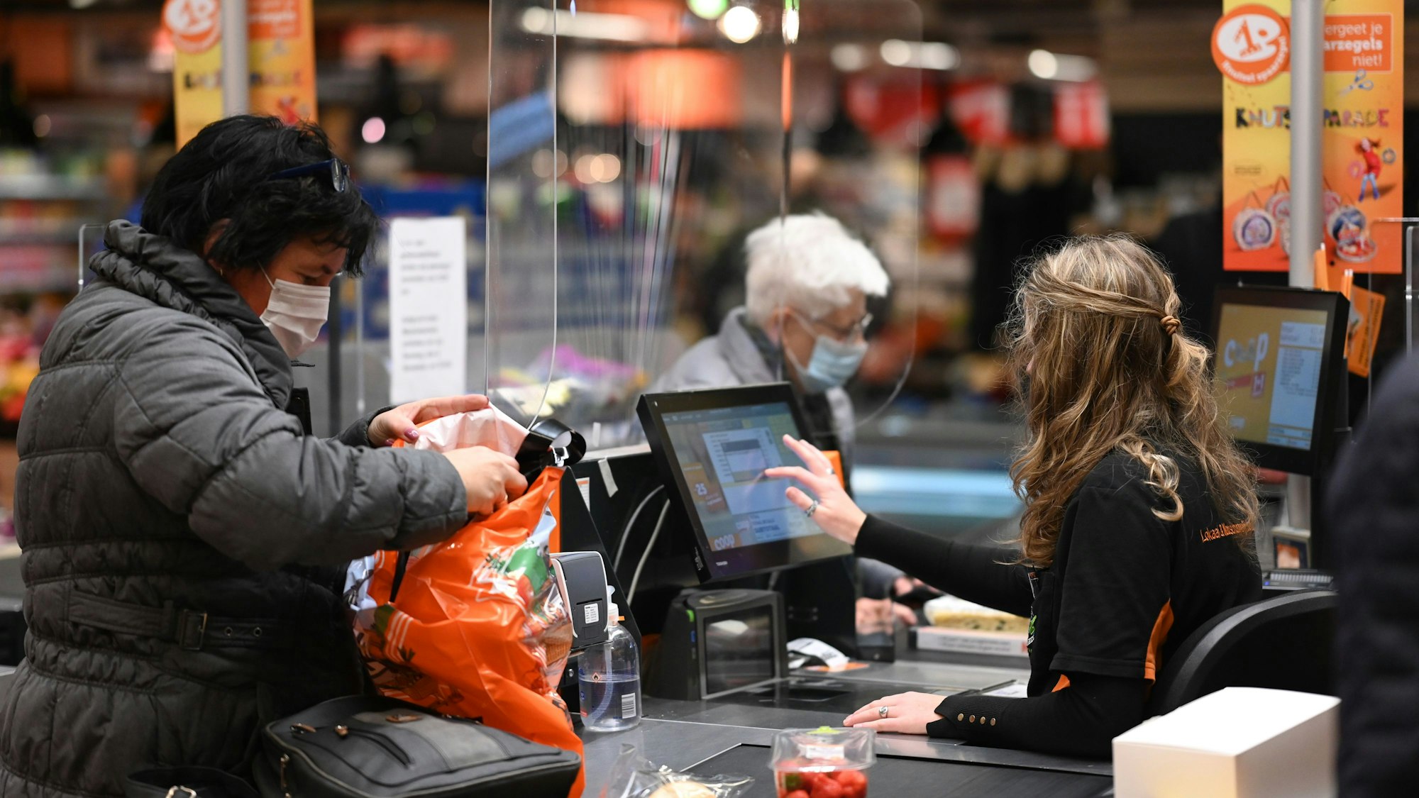 Kunden mit Mundschutz kaufen in einem Supermarkt ein. Symbolfoto von November 2021.