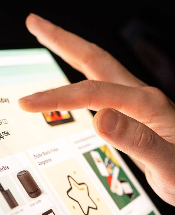 Eine Person schaut sich die Black Friday Angebote auf der Online-Shopping-Seite von Amazon auf seinem Tablet-Computer an.