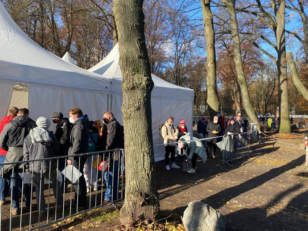 Menschen warten vor dem Impf-Zelt am Kölner Rhein-Energie-Stadion