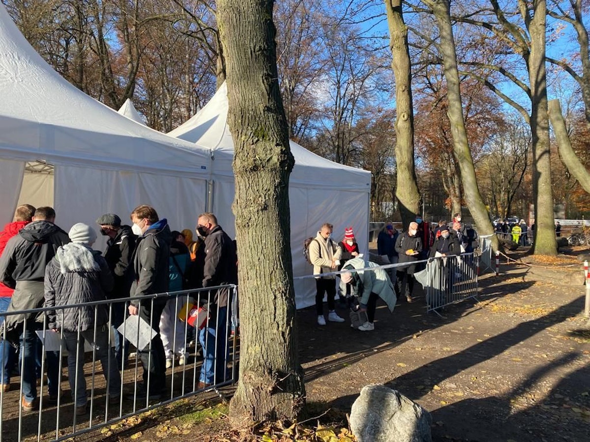 Menschen warten vor dem Impf-Zelt am Kölner Rhein-Energie-Stadion