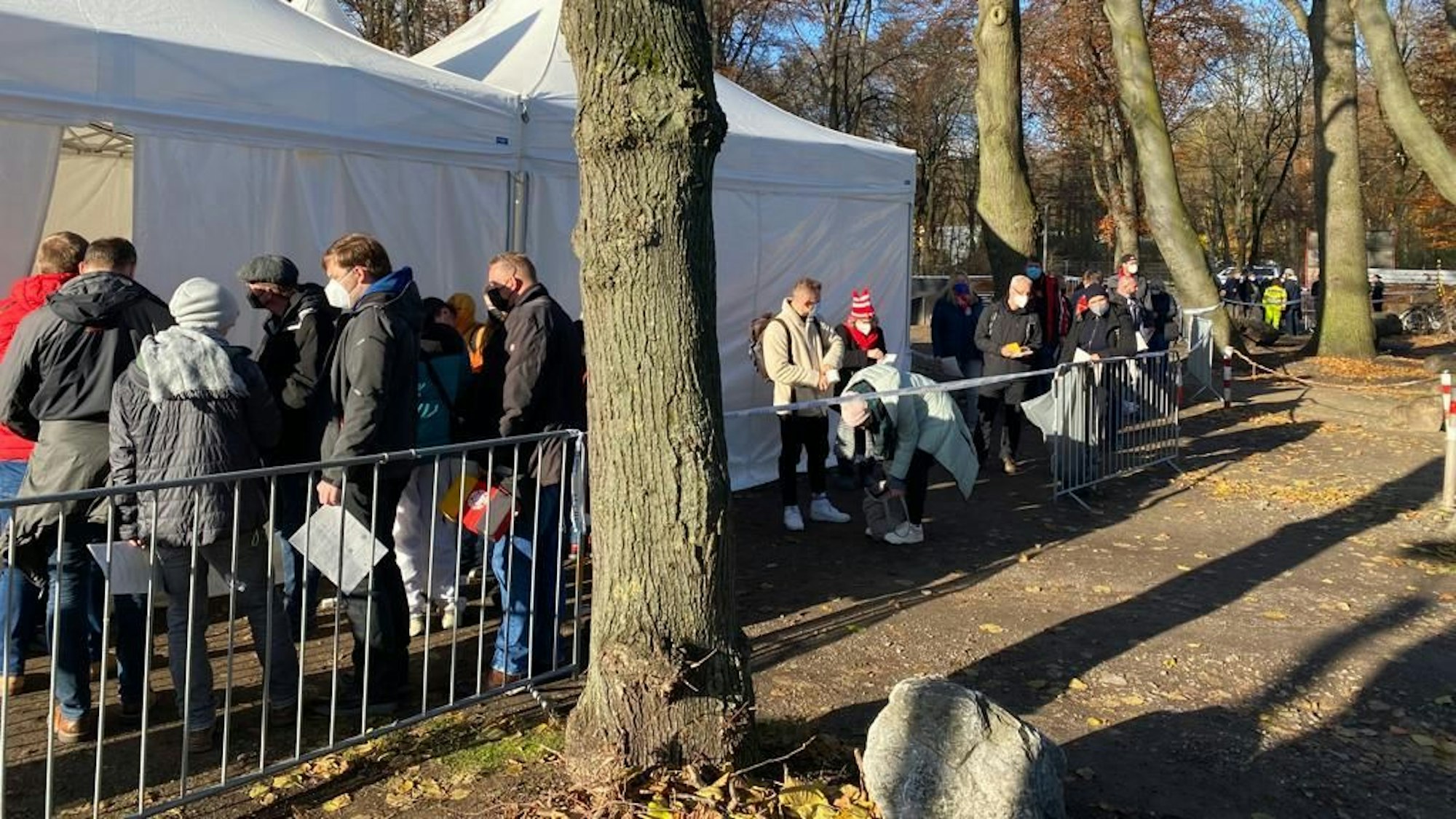 Menschen warten vor dem Impf-Zelt am Kölner Rhein-Energie-Stadion