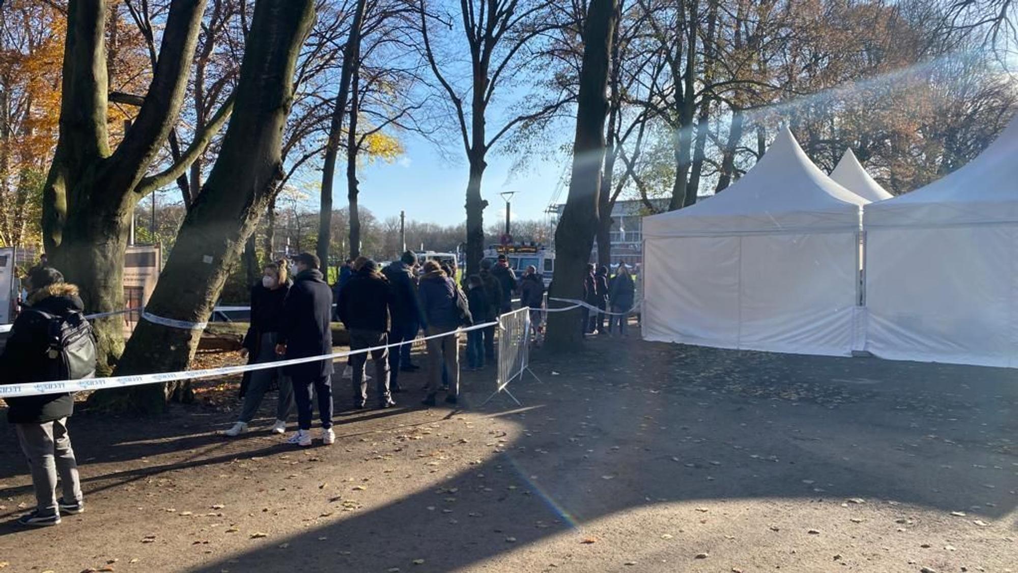 Menschen warten vor dem Impf-Zelt am Kölner Rhein-Energie-Stadion