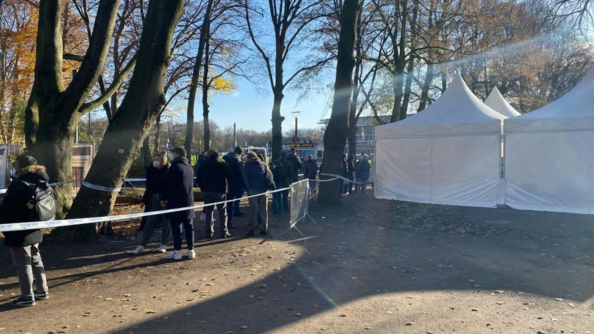 Menschen warten vor dem Impf-Zelt am Kölner Rhein-Energie-Stadion