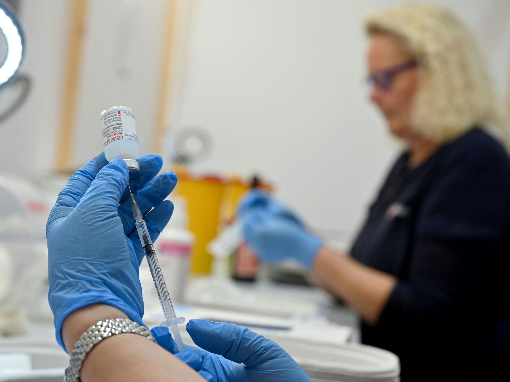 Eine medizinische Fachangestellte zieht am 25. November 2021 in einer Kabine in einem Impfzentrum eine Spritze mit dem Impfstoff Moderna auf.