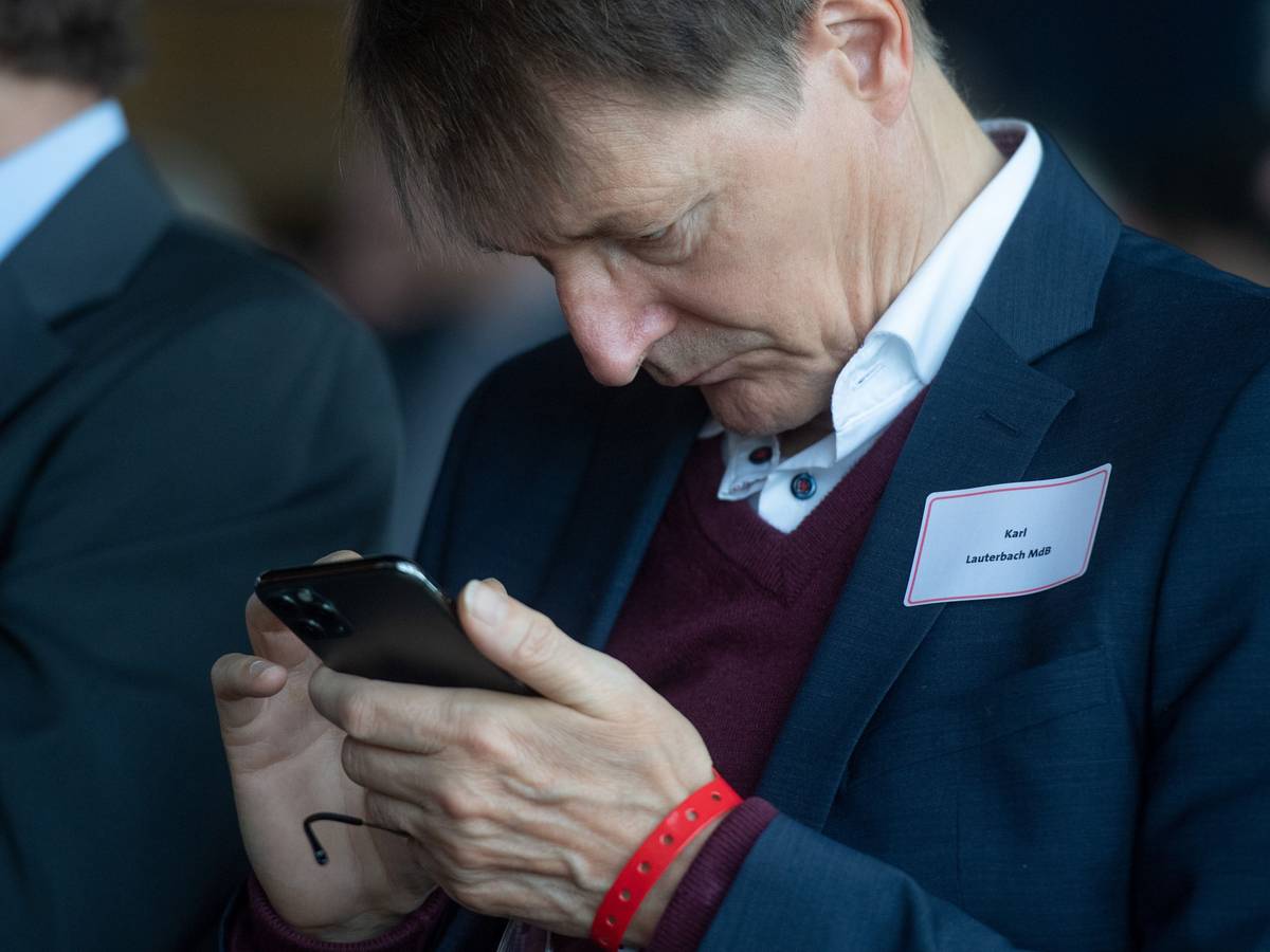 Karl Lauterbach, Gesundheitsexperte der SPD, schaut beim Empfang zum 75. Jubiläum der SPD-Fraktion Nordrhein-Westfalen auf sein Smartphone.