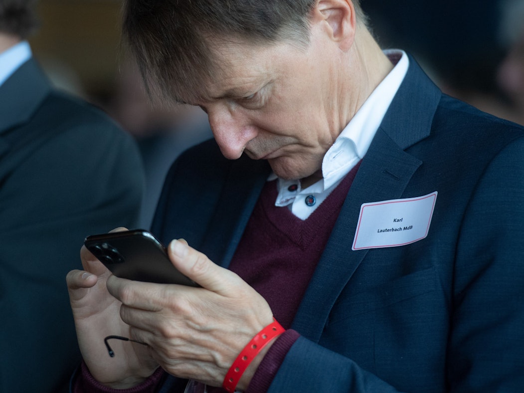 Karl Lauterbach schaut auf sein Smartphone
