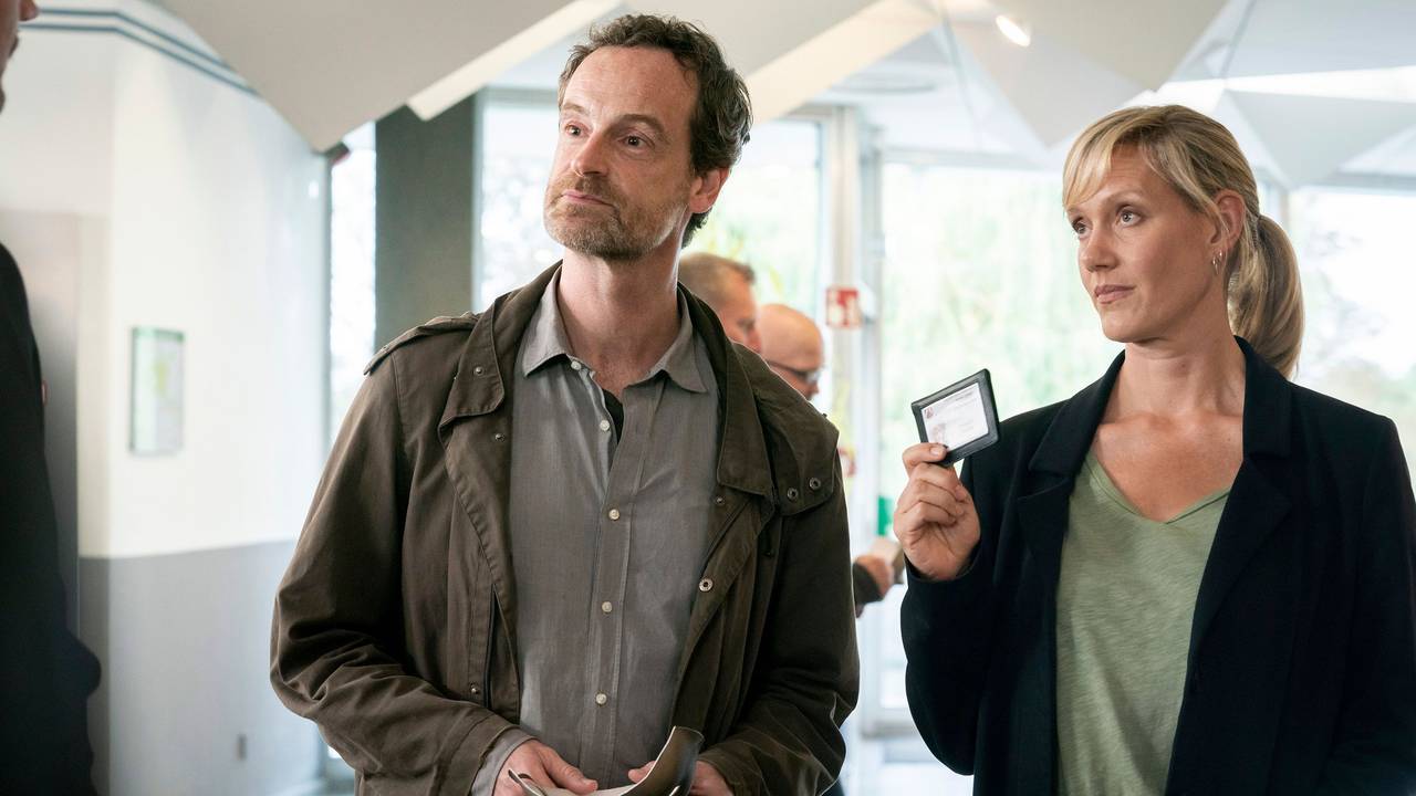 Peter Faber und Martina Bönisch stehen nebeneinander, Bönisch zeigt ihren Dienstausweis.