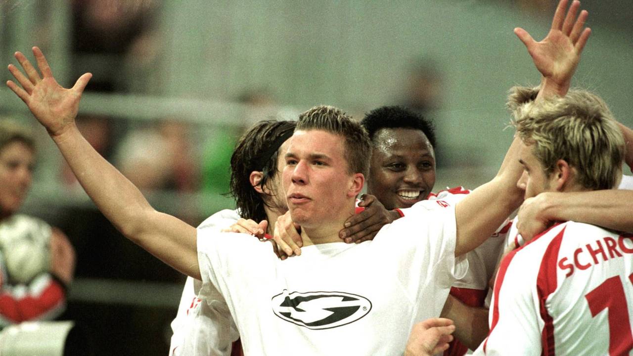 Lukas Podolski breitet beim Jubeln die Arme aus und wird umringt von seinen Mitspielern.