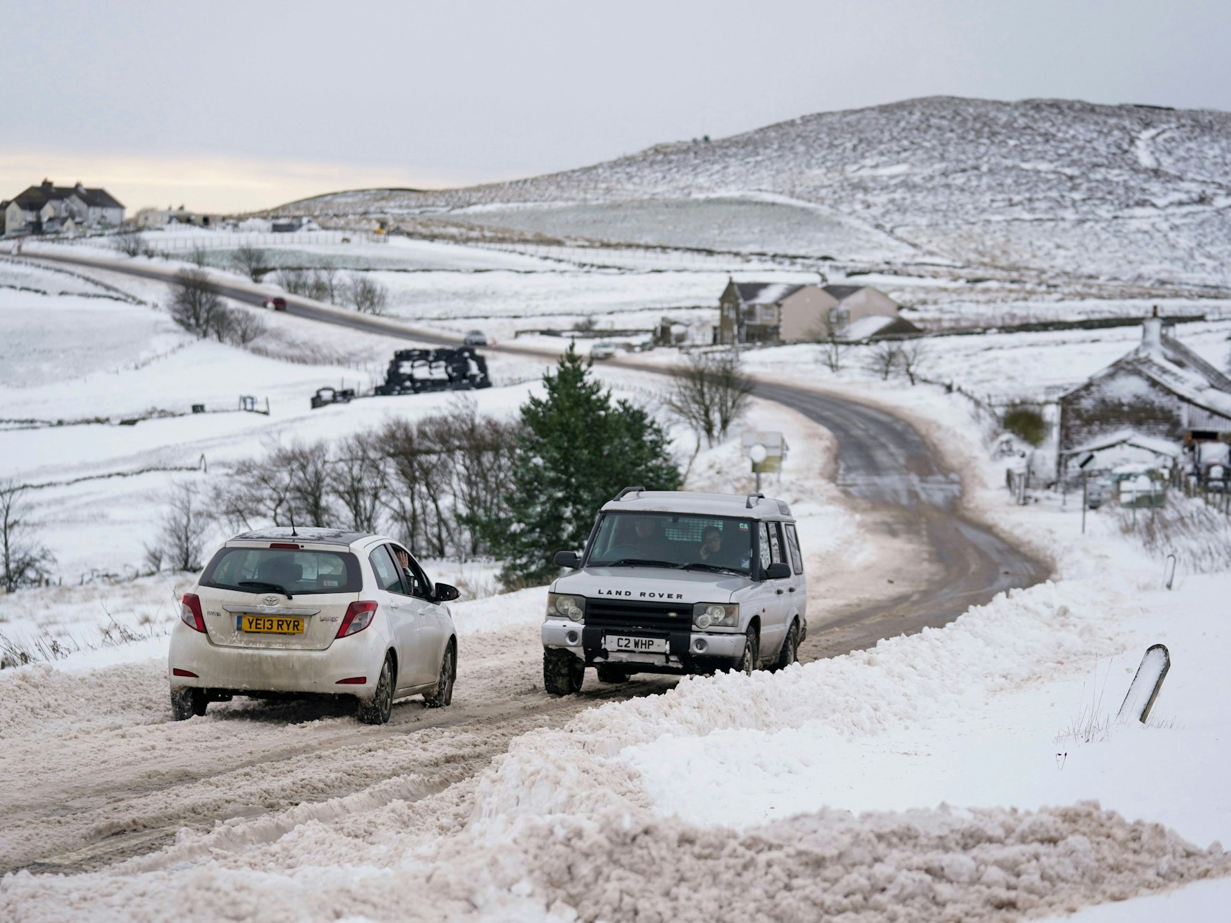 Vehicles travel tentatively on the snow-covered A53 close to Buxton in Derbyshire, amid freezing conditions in the aftermath of Storm Arwen, England, Sunday, Nov. 28, 2021. (Jacob King/PA via AP)