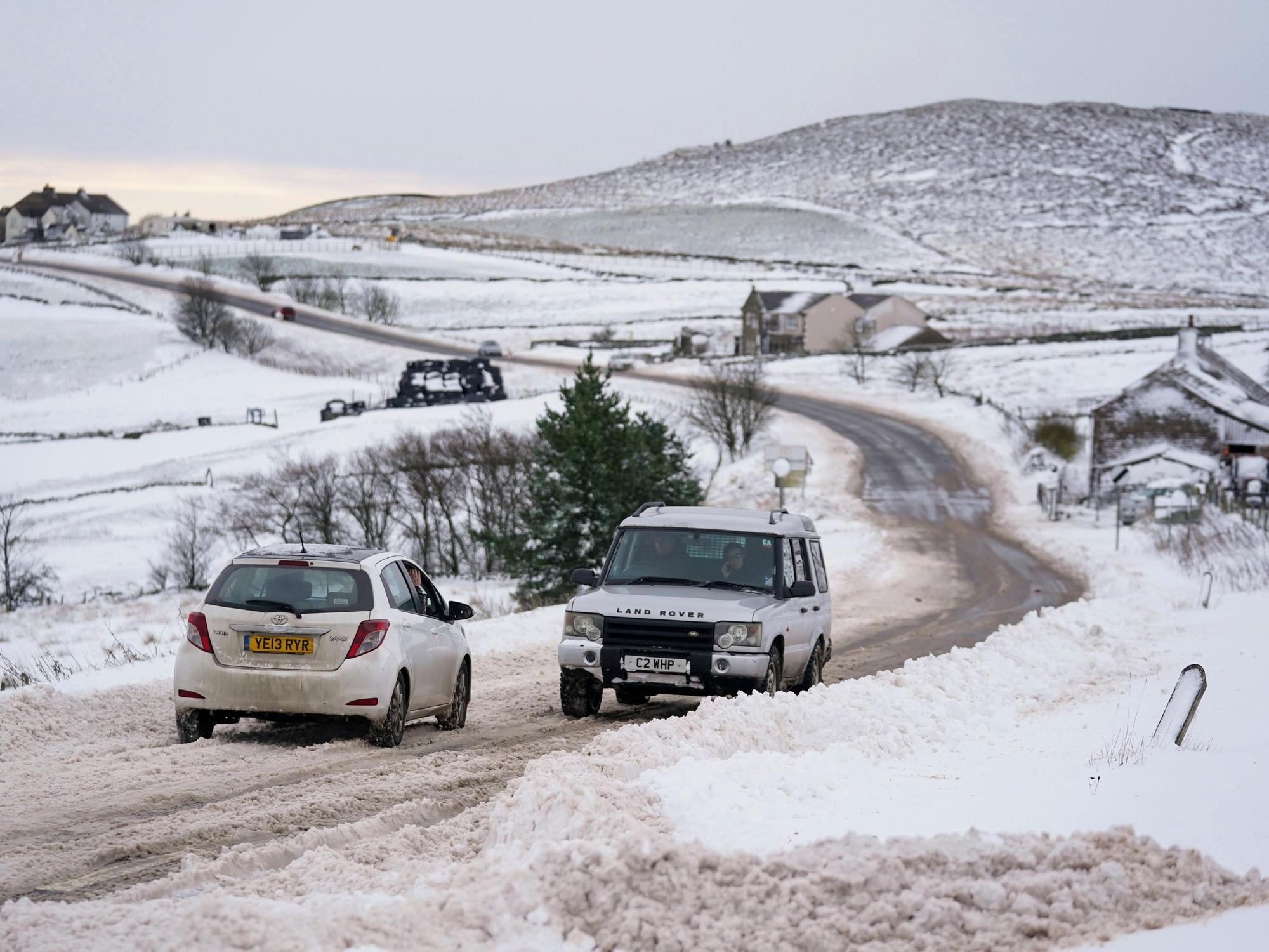Vehicles travel tentatively on the snow-covered A53 close to Buxton in Derbyshire, amid freezing conditions in the aftermath of Storm Arwen, England, Sunday, Nov. 28, 2021. (Jacob King/PA via AP)