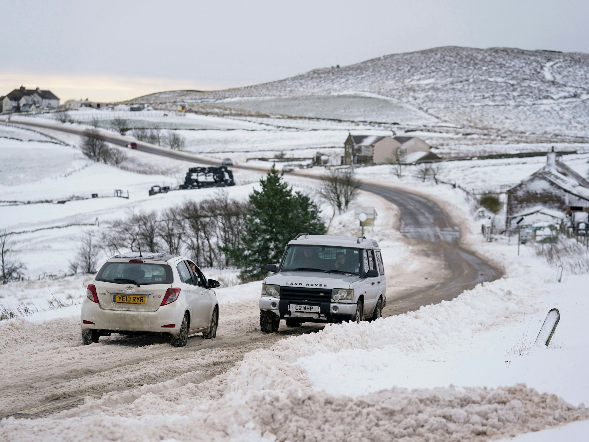 Vehicles travel tentatively on the snow-covered A53 close to Buxton in Derbyshire, amid freezing conditions in the aftermath of Storm Arwen, England, Sunday, Nov. 28, 2021. (Jacob King/PA via AP)