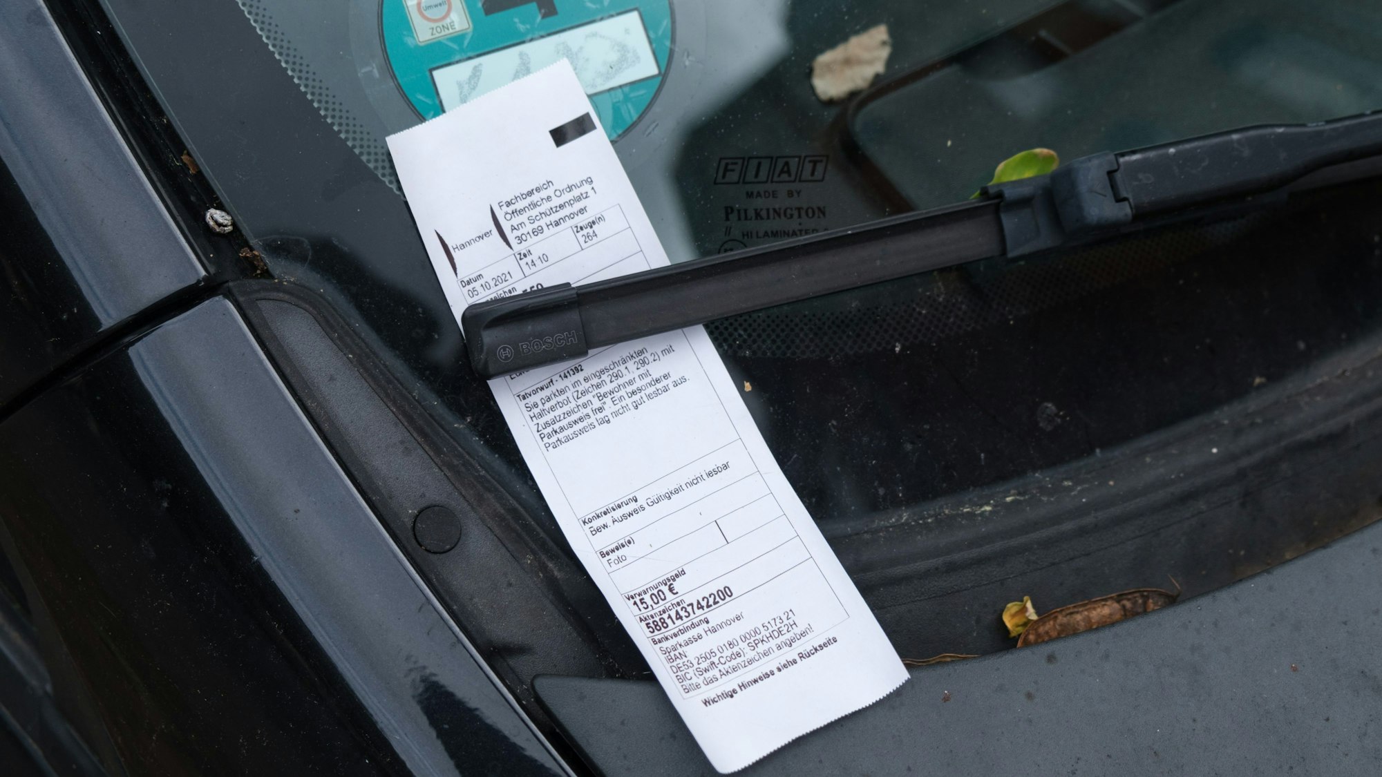 Das Symbolfoto (aufgenommen am 6. November 2021 in Hannover) zeigt einen Strafzettel, der hinter einem Scheibenwischer klemmt.