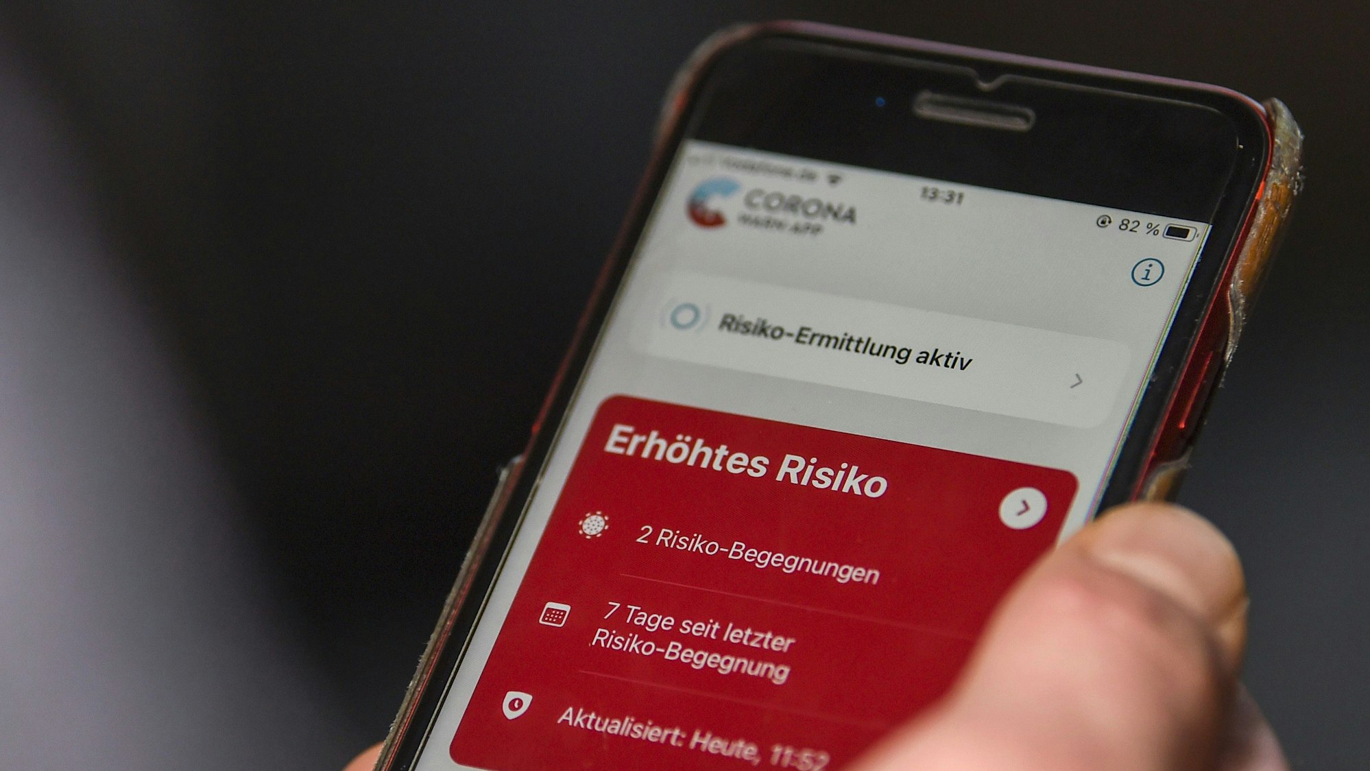 Auf einem Handy ist die Corona-Warn-App geöffnet und zeigt ein erhöhtes Risiko an.