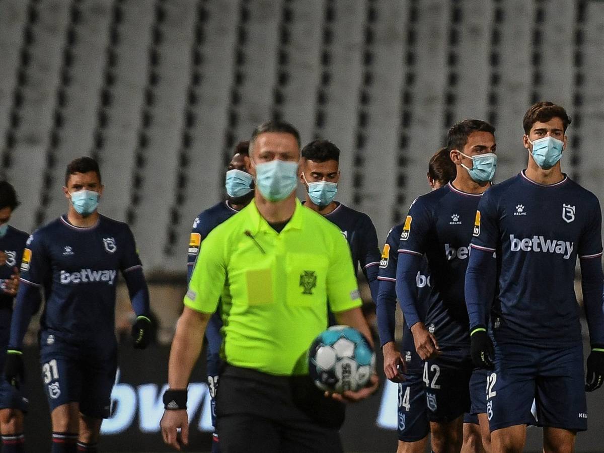 Die Spieler von Belenenses Lissabon und der Schiedsrichter gehen mit Masken auf den Platz.