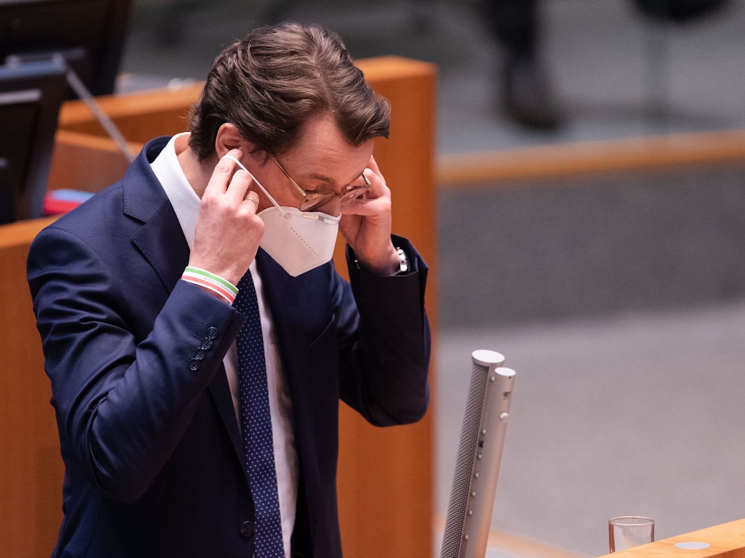 Hendrik Wüst (CDU), Ministerpräsident von Nordrhein-Westfalen, setzt nach seiner Rede im Landtag seine FFP2-Maske auf.