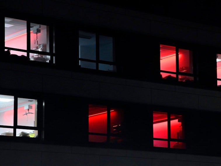 Zum Schichtwechsel des Personals ist die Zimmerbeleuchtung in der Intensivstation des RoMed-Klinikums Rosenheim für kurze Zeit auf die Farbe Rot eingestellt.