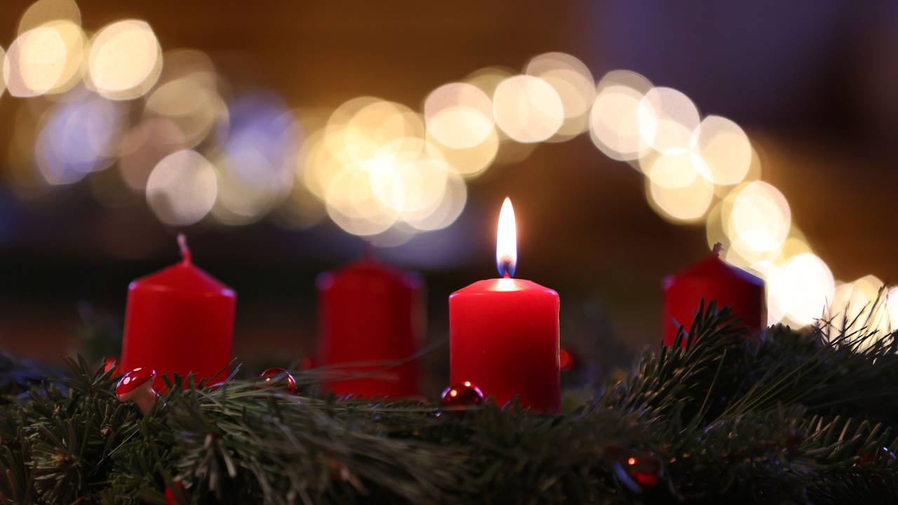 Auf dem Symbolfoto sieht man eine Kerze auf einem Adventskranz brennen.