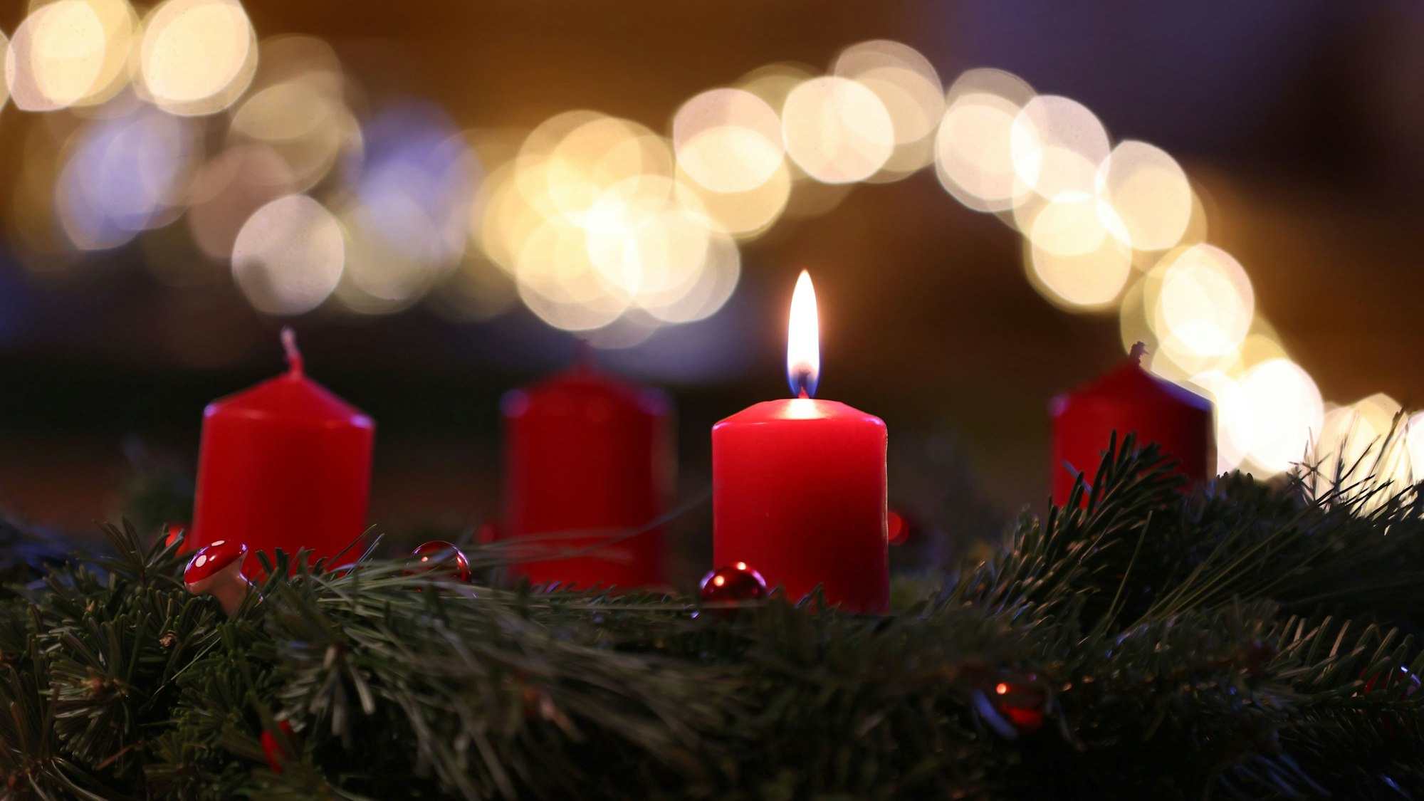 Auf dem Symbolfoto sieht man eine Kerze auf einem Adventskranz brennen.