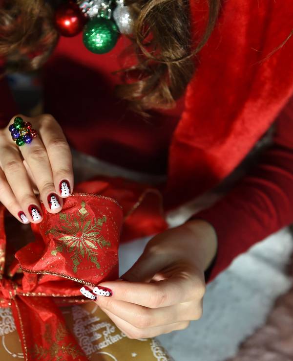 Auf dem Foto sieht man die Hände einer jungen Frau und ein großes Weihnachtsgeschenk.