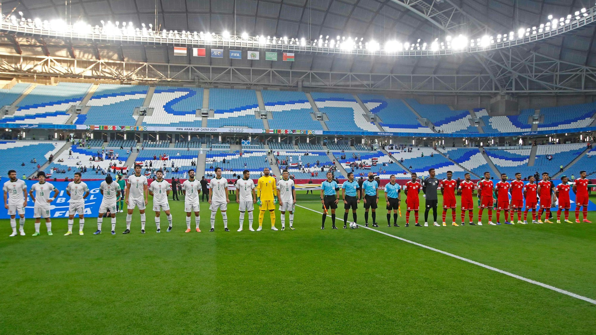 Die Spieler vom Irak und aus Oman stehen auf dem Feld.
