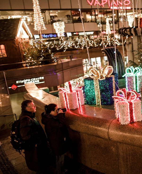 Besucher gehen an Weihnachtsdekorationen auf dem Weihnachtsmarkt am Breitscheidplatz vorbei.
