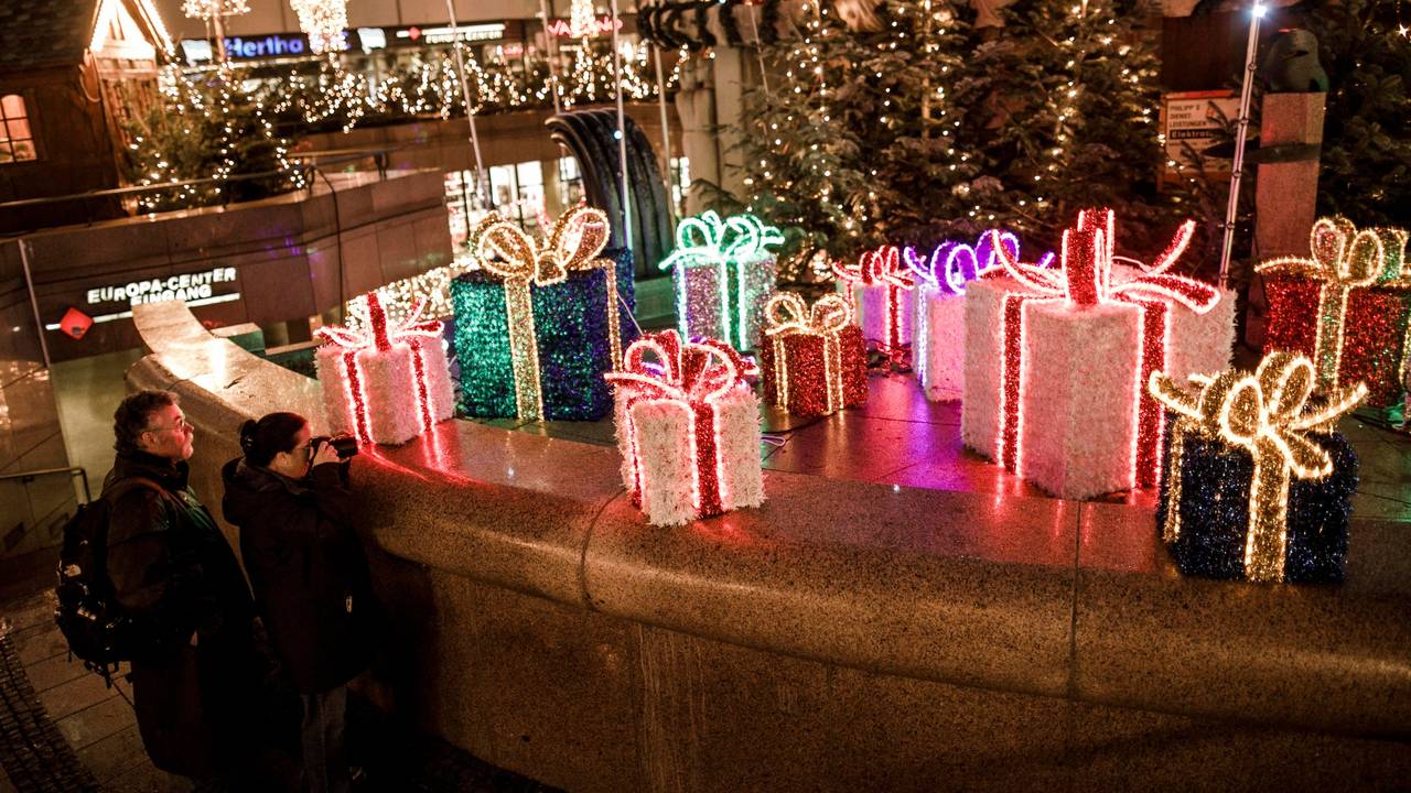 Besucher gehen an Weihnachtsdekorationen auf dem Weihnachtsmarkt am Breitscheidplatz vorbei.