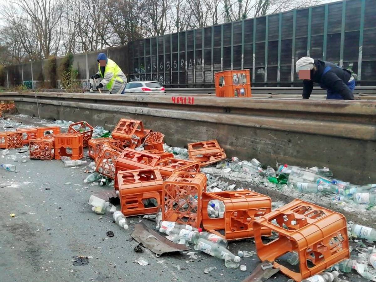 Nach einem Unfall auf der A555 liegen zahlreiche Getränkekisten und Flaschen an der Leitplanke.