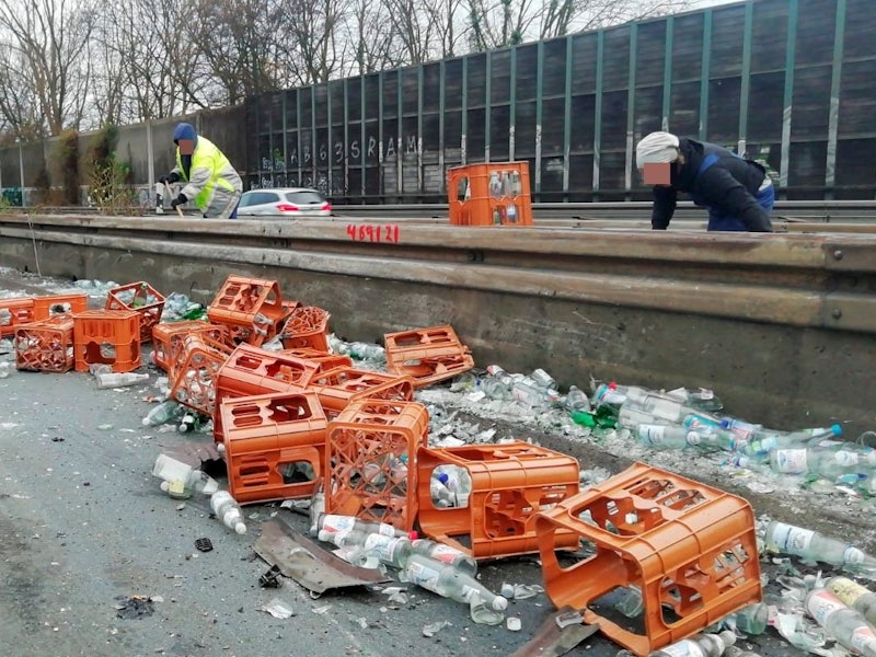 Nach einem Unfall auf der A555 liegen zahlreiche Getränkekisten und Flaschen an der Leitplanke.