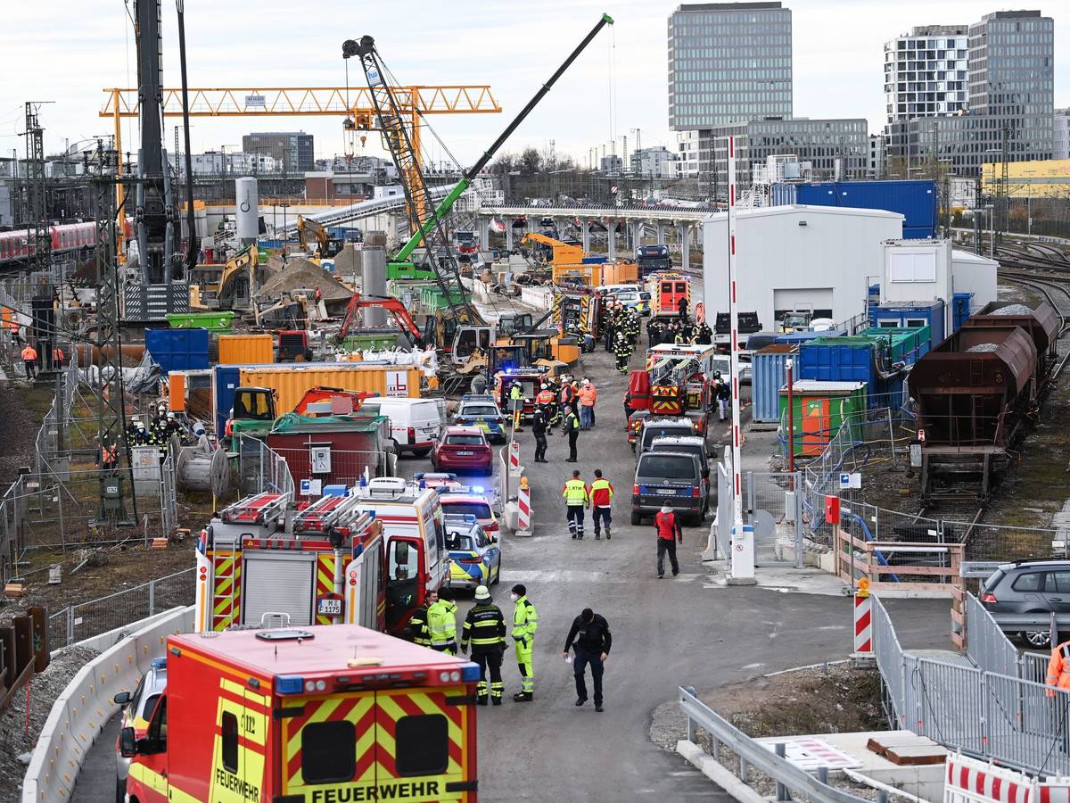 Feuerwehrleute, Polizisten und Bahnbedienstete stehen in München auf einem Bahngelände an der Donnersbergerbrücke.