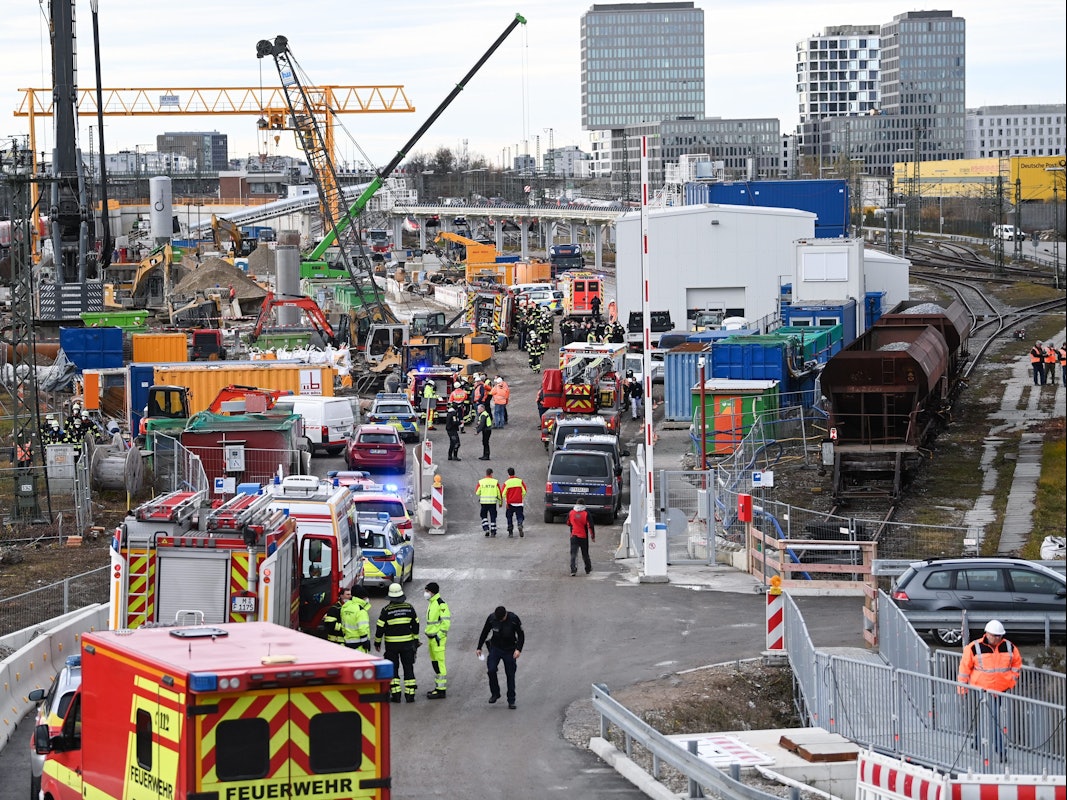 Feuerwehrleute, Polizisten und Bahnbedienstete stehen in München auf einem Bahngelände an der Donnersbergerbrücke.