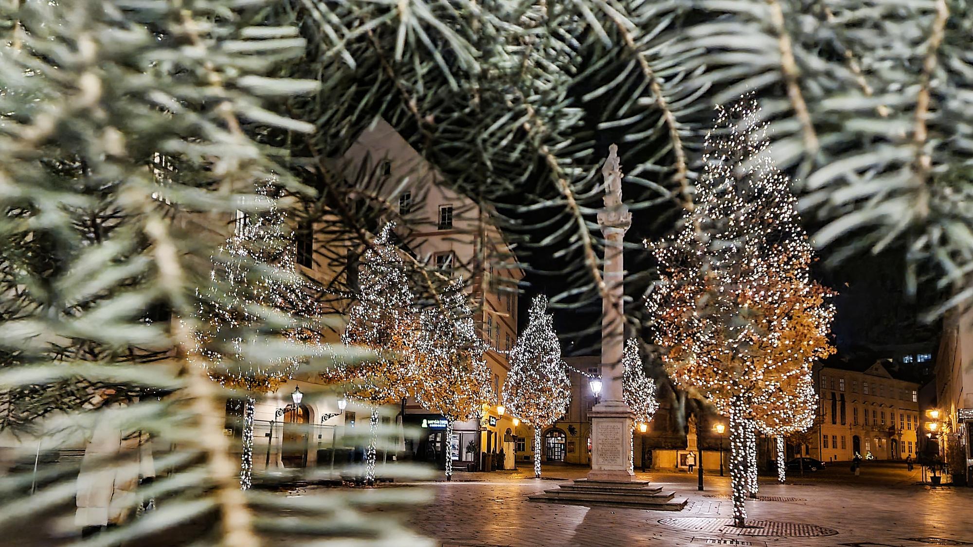 Ein offener Platz in Bratislava ist weihnachtlich beleuchtet.