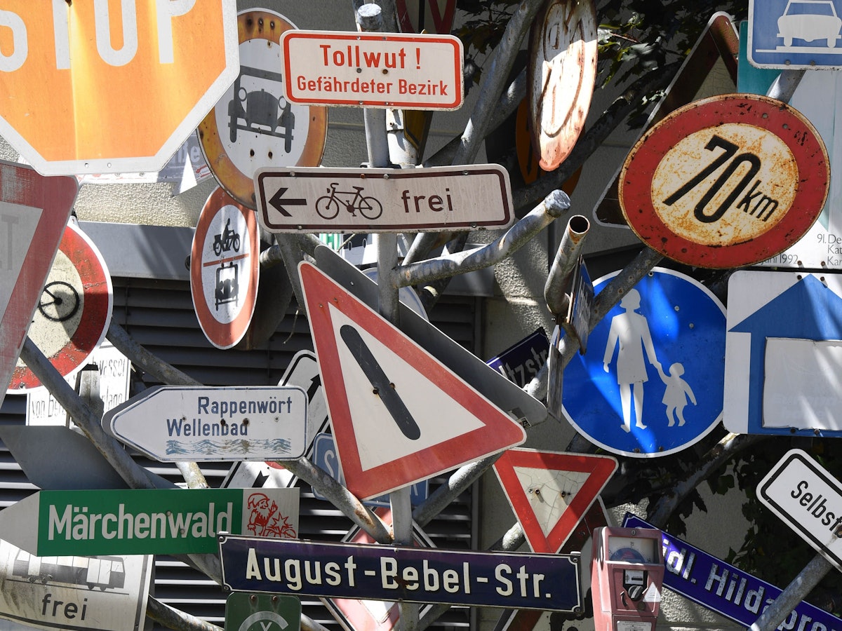 Ein Schilderbaum steht beim Tiefbauamt in Bayern. Dieser besteht aus ausrangierten Verkehrs- und Hinweisschildern.