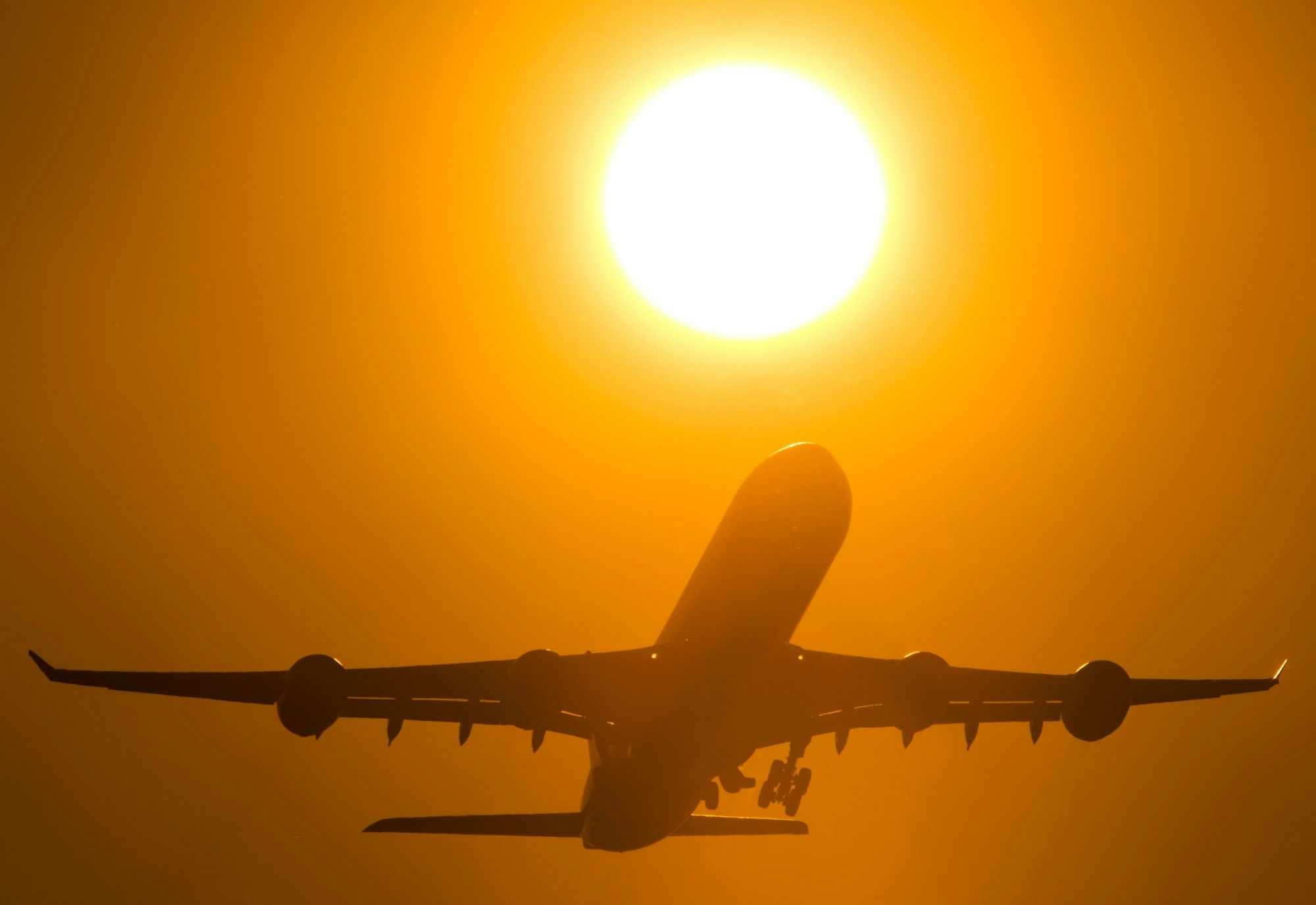 Ein Flugzeug startet am 9. März 2013 vom Flughafen Frankfurt (Hessen) aus in den Sonnenuntergang.