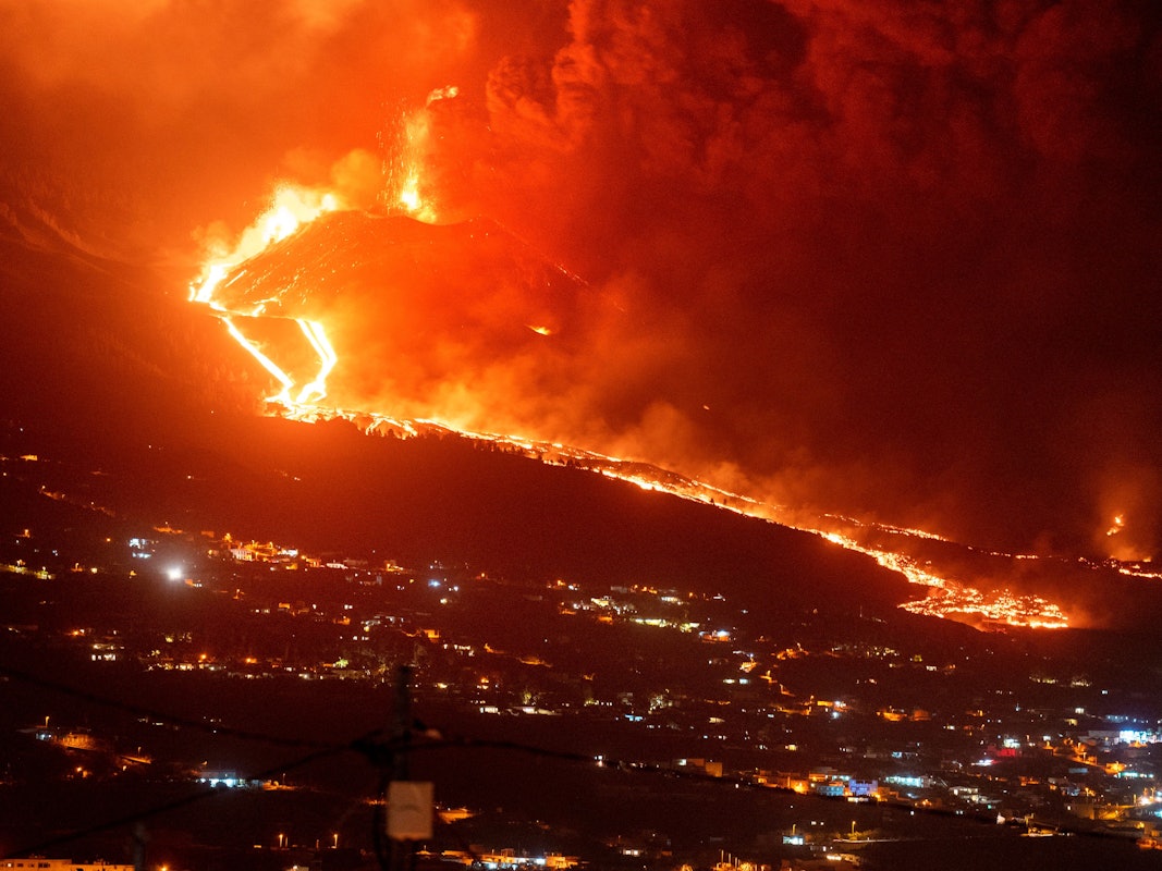 Glühende Lava fließt bei einem weiteren Vulkanausbruch in der Nacht einen Berg hinunter. Mehrere neue Vulkanschlote hatten sich am Sonntag, 28.11.2021 auf La Palma geöffnet und setzten neue Lava frei, die schnell einen Bergrücken hinunterfloss und weitere Siedlungen bedrohte.
