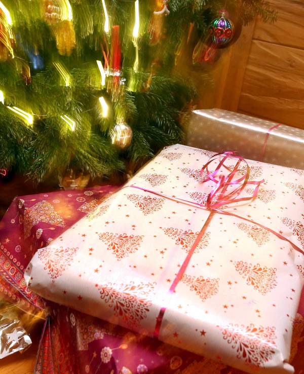 Weihnachtsgeschenke liegen unter einem geschmücktem Christbaum.