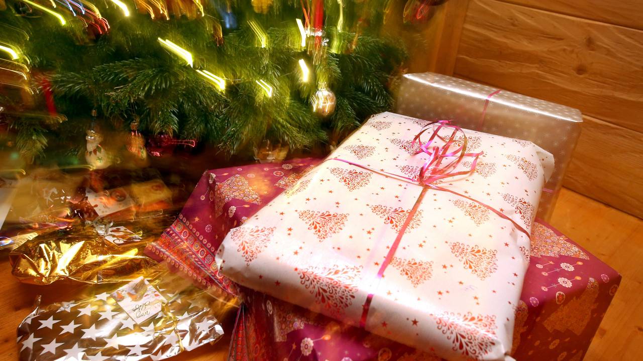 Weihnachtsgeschenke liegen unter einem geschmücktem Christbaum.